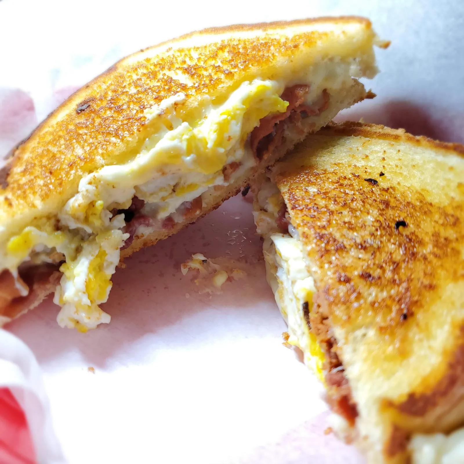 Bacon, egg and cheese breakfast grilled cheese sandwich cut in half